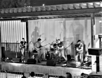black and white image of The Blips on outdoor stage