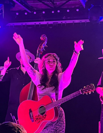 Sierra Elizabeth Ferrell on stage with guitar