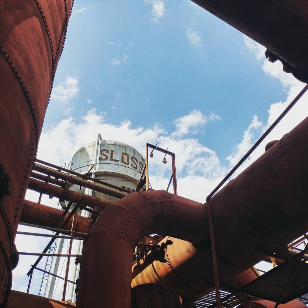 view of the water tower at Sloss Furnace through pipes